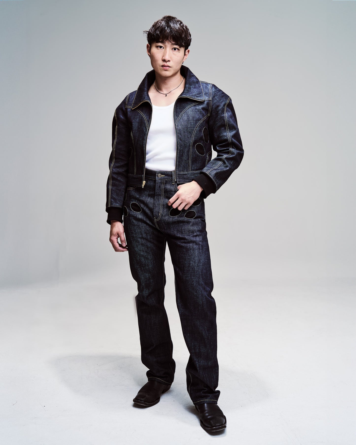 Structured, avant garde blue denim jacket with exaggerated and big shoulders.  Paired with cargo heavy denim straight leg pants with circular pocket detailing. 